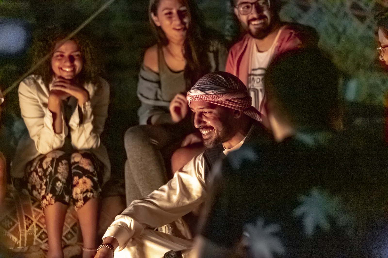 Faces lit by firelight under the night sky